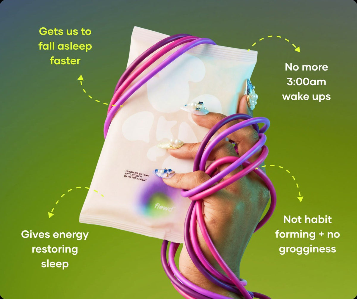 Flewd fragrance-free Insomnia Ending bath soak clear pouch held in a hand wrapped in purple cables, for sleepless nights