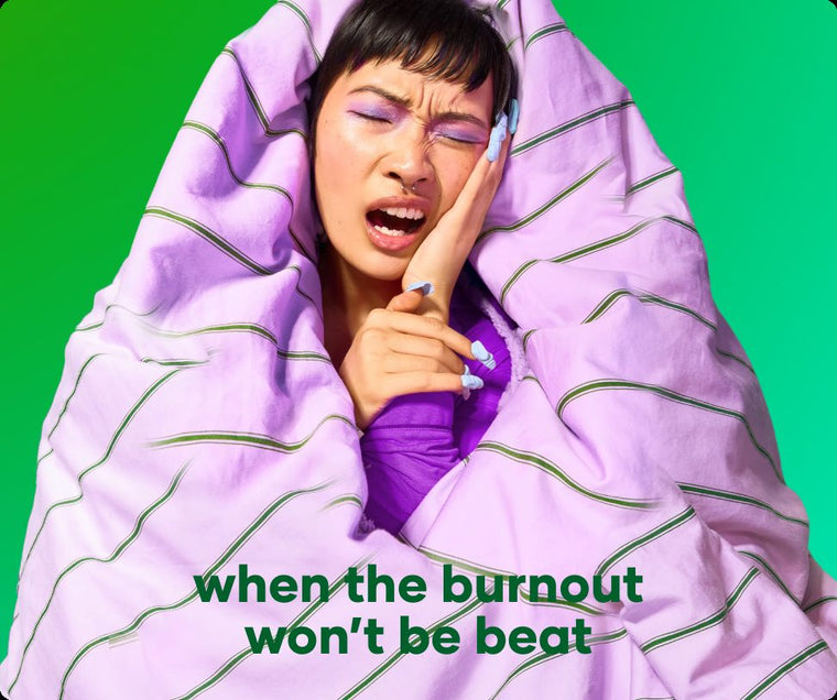 Woman wrapped in a lilac duvet, yawning on a burnt-out day