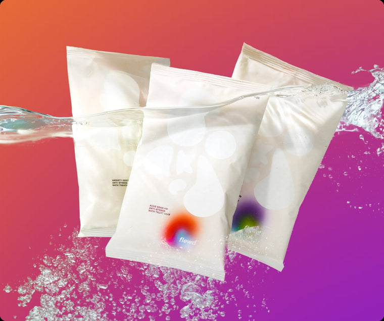 Three Stresscare Trio magnesium bath soak pouches with a water splash